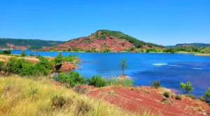 Lac avec terre rouge autour et verdure